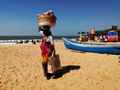Разносчица фруктов легко несёт на голове тяжёлую корзину. Пляж Бага бич, Гоа (Индия). Январь 2020г